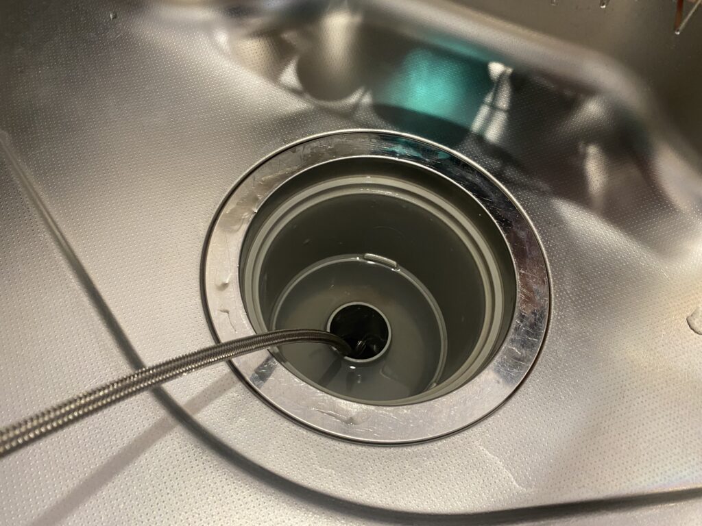 キッチンの排水口に洗浄ホースを挿入した様子